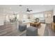 Bright living room featuring wood floors, ceiling fan, and comfortable furniture at 6902 8Th W Ave, Bradenton, FL 34209