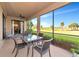 Outdoor dining area on a screened-in lanai with views of the green landscaped lawn at 6918 Grand Estuary Trl # 104, Bradenton, FL 34212