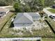 This aerial view shows a new construction home on an undeveloped treed lot in a neighborhood at 6970 Beckwith Ave, North Port, FL 34291