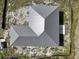 An aerial view shows the angles of the metal roof of a new home in a treed lot at 6970 Beckwith Ave, North Port, FL 34291