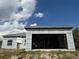 Shows the garage opening of an unfinished one-story home with a metal roof, with cloudy blue skies at 6970 Beckwith Ave, North Port, FL 34291