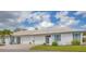 Charming single-story villa with tile roof, white exterior and vibrant blue shutters and accents at 7402 8Th W Ave, Bradenton, FL 34209