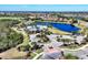 Aerial view showcases community pool, lake, club house, mature trees and lush landscaping at 7469 Seacroft Cv, Lakewood Ranch, FL 34202