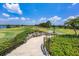 Scenic golf course view with lush greenery, stone accents, and stairs leading to the course at 7469 Seacroft Cv, Lakewood Ranch, FL 34202