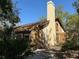 Back exterior with a view of the chimney and trees at 7523 4Th W Ave # 7523, Bradenton, FL 34209