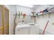 Functional laundry room with washer, dryer, storage shelves, and wood slat door at 7523 4Th W Ave # 7523, Bradenton, FL 34209