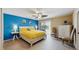 Bright main bedroom featuring a blue accent wall, ceiling fan, and access to the patio at 7523 4Th W Ave # 7523, Bradenton, FL 34209
