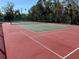 Well-maintained community tennis court with a red and green surface, perfect for an active lifestyle at 7523 4Th W Ave # 7523, Bradenton, FL 34209