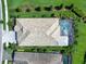 Aerial view of a house with a screened-in pool, well-maintained landscaping, lush green grass, and surrounding trees at 813 Tailwind Pl, Sarasota, FL 34240
