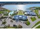Aerial view of the community clubhouse with a pool, lawn, parking, and lake at 813 Tailwind Pl, Sarasota, FL 34240