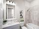 Well-lit bathroom featuring a tiled shower and tub, a modern vanity, and elegant decor at 813 Tailwind Pl, Sarasota, FL 34240