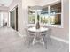 Bright breakfast nook features a white round table, four chairs, large windows and modern lighting at 813 Tailwind Pl, Sarasota, FL 34240
