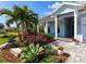 Charming exterior view with well-manicured landscaping, blooming flowers, and a covered porch with stylish columns at 813 Tailwind Pl, Sarasota, FL 34240