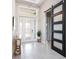 Bright foyer with a decorative frosted-glass front door, gray porcelain tile floors, and stylish sliding barn door at 813 Tailwind Pl, Sarasota, FL 34240