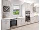 Kitchen with stainless steel appliances including a wine cooler, double oven, and modern gray cabinets at 813 Tailwind Pl, Sarasota, FL 34240