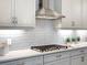 Kitchen features a stainless steel hood, under cabinet lighting, gray cabinets and quartz countertops at 813 Tailwind Pl, Sarasota, FL 34240
