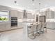 Modern kitchen features an island with seating, stainless steel appliances and sleek gray cabinetry at 813 Tailwind Pl, Sarasota, FL 34240