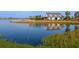 Picturesque lake view with a boathouse, dock, and lush landscaping around the property at 813 Tailwind Pl, Sarasota, FL 34240