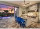 Outdoor kitchen with bar seating overlooking a pool and a beautiful sunset at 813 Tailwind Pl, Sarasota, FL 34240