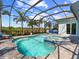 A screened-in pool and spa with views of palm trees and a lush backyard at 813 Tailwind Pl, Sarasota, FL 34240