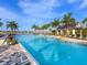 A community pool area featuring a covered lounge area and lush landscaping at 813 Tailwind Pl, Sarasota, FL 34240
