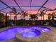 A screened-in pool and spa with tiled border surrounded by palm trees and a sunset view at 813 Tailwind Pl, Sarasota, FL 34240