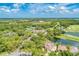 Overhead view of the golf course, community amenities, and surrounding homes nestled among mature trees and water features at 8782 49Th E Ter, Bradenton, FL 34211