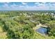 Aerial perspective showcasing the golf course, community amenities, and pond, all surrounded by mature trees and greenery at 8782 49Th E Ter, Bradenton, FL 34211