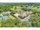 An aerial view shows a luxurious community, featuring a clubhouse, tennis courts, a pool, and a golf course at 8782 49Th E Ter, Bradenton, FL 34211