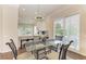 Cozy dining area with a glass table, unique chairs, modern lighting, and seamless access to the kitchen and outdoor patio at 8782 49Th E Ter, Bradenton, FL 34211
