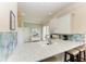 Stylish kitchen counter with a sink, tiled backsplash, and seating, perfect for casual dining and food preparation at 8782 49Th E Ter, Bradenton, FL 34211