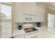 Well-equipped kitchen with modern appliances, white cabinets, and a stylish countertop, offering a functional cooking space at 8782 49Th E Ter, Bradenton, FL 34211