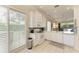 Bright kitchen with white cabinets and appliances, view to the breakfast nook and window with white blinds at 8782 49Th E Ter, Bradenton, FL 34211
