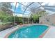 A refreshing screened-in pool with lounge chairs, a table, and lush greenery creates a serene outdoor retreat at 8782 49Th E Ter, Bradenton, FL 34211