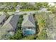 An aerial view shows a screened-in pool surrounded by lush greenery and a gray tiled roof in a quiet neighborhood at 8782 49Th E Ter, Bradenton, FL 34211