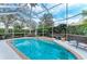 Inviting screened-in pool with sun loungers and lush landscaping offers a tranquil backyard oasis at 8782 49Th E Ter, Bradenton, FL 34211