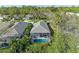 An aerial view shows a screened-in pool surrounded by lush greenery and a gray tiled roof in a quiet neighborhood at 8782 49Th E Ter, Bradenton, FL 34211