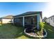 Enclosed back porch overlooking manicured lawn and a garden bed at 922 Fernleaf Run, Bradenton, FL 34212