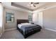Spacious bedroom with a ceiling fan, tray ceiling and ample natural light from dual windows at 922 Fernleaf Run, Bradenton, FL 34212