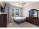 Neutral bedroom featuring two windows, ceiling fan, and a lovely dark wood dresser with mirror at 922 Fernleaf Run, Bradenton, FL 34212