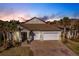 Inviting home with a three-car garage, mature landscaping, and paver driveway at 922 Fernleaf Run, Bradenton, FL 34212