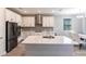 Modern kitchen with stainless steel appliances, ample counter space, and stylish white cabinetry at 922 Fernleaf Run, Bradenton, FL 34212