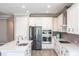 Open kitchen featuring stainless steel appliances, white cabinets, and a center island with sink at 922 Fernleaf Run, Bradenton, FL 34212
