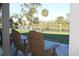 Relaxing view from the covered patio with comfortable seating overlooking the peaceful waterfront at 922 Fernleaf Run, Bradenton, FL 34212