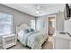 Cozy bedroom with a ceiling fan, TV, and ensuite bathroom entrance creating a serene retreat at 110 167Th E Blvd, Bradenton, FL 34212