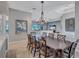 Dining area with elegant chandelier, neutral colors, and an open layout flowing into the living area at 110 167Th E Blvd, Bradenton, FL 34212