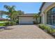 Spacious garage and brick driveway bordered by mature landscaping at 110 167Th E Blvd, Bradenton, FL 34212