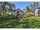 Well-manicured lawn surrounds a charming single-story home with mature landscaping at 110 167Th E Blvd, Bradenton, FL 34212