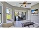 Bright living room with view of pool area through sliding glass doors, tiled floor, and ceiling fan at 110 167Th E Blvd, Bradenton, FL 34212