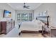 Bright main bedroom featuring a ceiling fan, TV, and views from the three windows overlooking the lawn at 110 167Th E Blvd, Bradenton, FL 34212